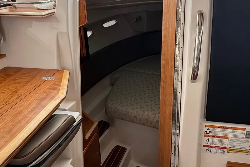 Slide: The Image of 2025 Cutwater C-32 CB cabin interior with wooden accents and cozy sleeping area. - 21