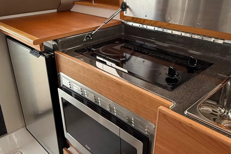 Slide: The Image of 2025 Cutwater C-32 CB yacht kitchen with stove, oven, and fridge. - 25