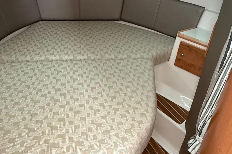 Slide: The Image of 2025 Cutwater C-32 CB cabin interior with patterned bedding and wooden accents. - 26