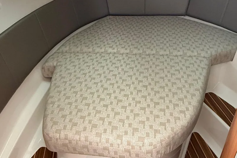 Slide: The Image of 2025 Cutwater C-32 CB cabin interior with patterned bedding and wooden flooring. - 27