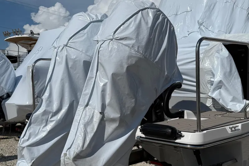 Slide: The Image of 2025 Cutwater C-32 CB boat covered in protective tarp, docked outdoors. - 3
