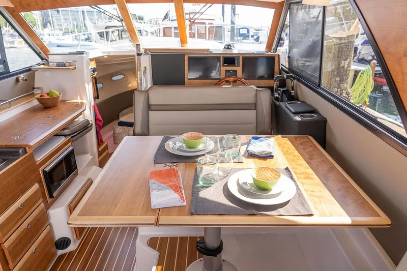 Slide: The Image of Manufacturer Provided Image: Interior of 2025 Cutwater C-32 CB boat with dining area and helm station. - 33