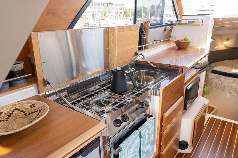 Slide: The Image of Manufacturer Provided Image: Modern kitchen interior of 2025 Cutwater C-32 CB boat with wooden cabinetry and appliances. - 37