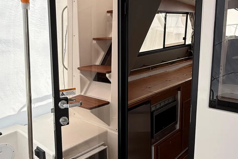 Slide: The Image of 2025 Cutwater C-32 CB interior with wooden stairs and kitchenette. - 6