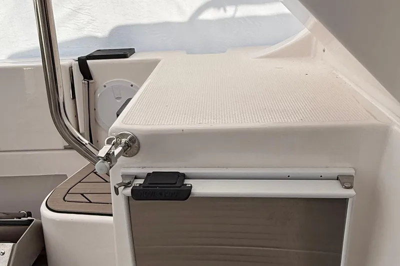 Slide: The Image of 2025 Cutwater C-32 CB boat interior detail with stainless steel railing and storage compartment. - 8