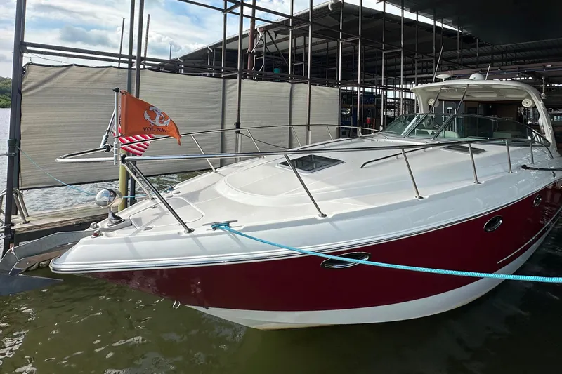 Slide: The Image of 2010 Chaparral Signature 370 boat docked, featuring sleek design and vibrant red hull. - 1