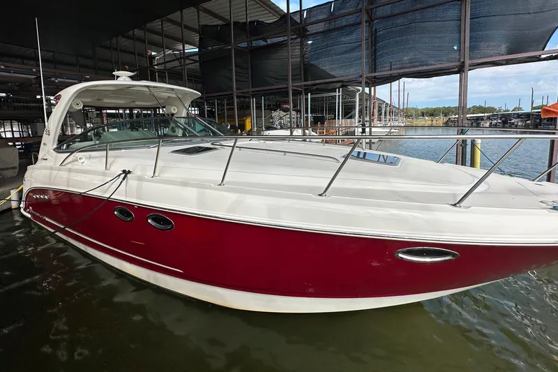 Slide: The Image of 2010 Chaparral Signature 370 boat docked, featuring a sleek red and white design. - 11