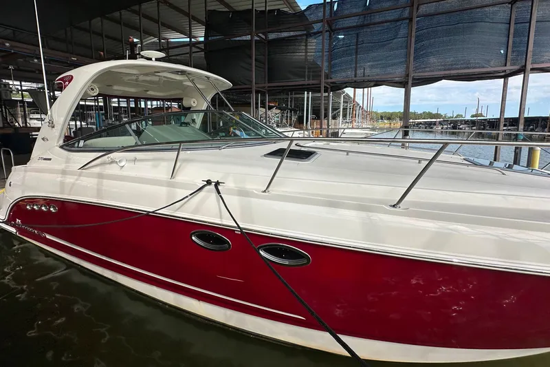 Slide: The Image of 2010 Chaparral Signature 370 boat docked, featuring a sleek red and white design. - 12