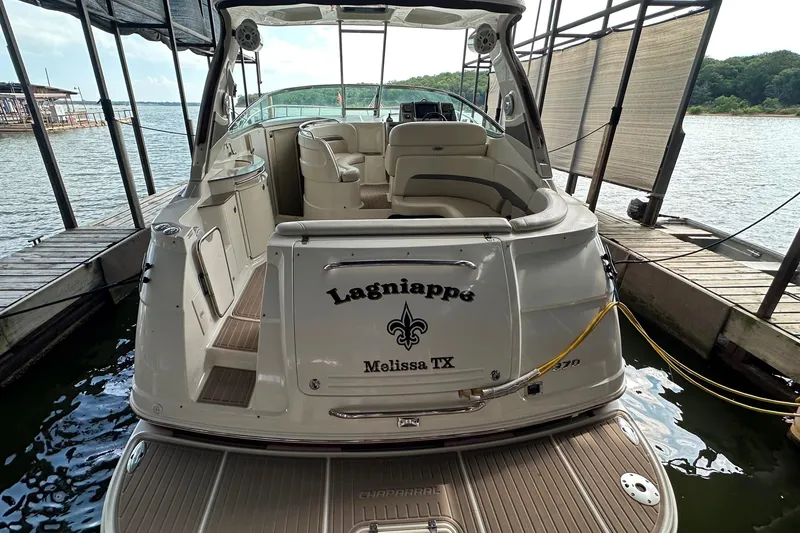 Slide: The Image of 2010 Chaparral Signature 370 boat docked, rear view with seating and water backdrop. - 14