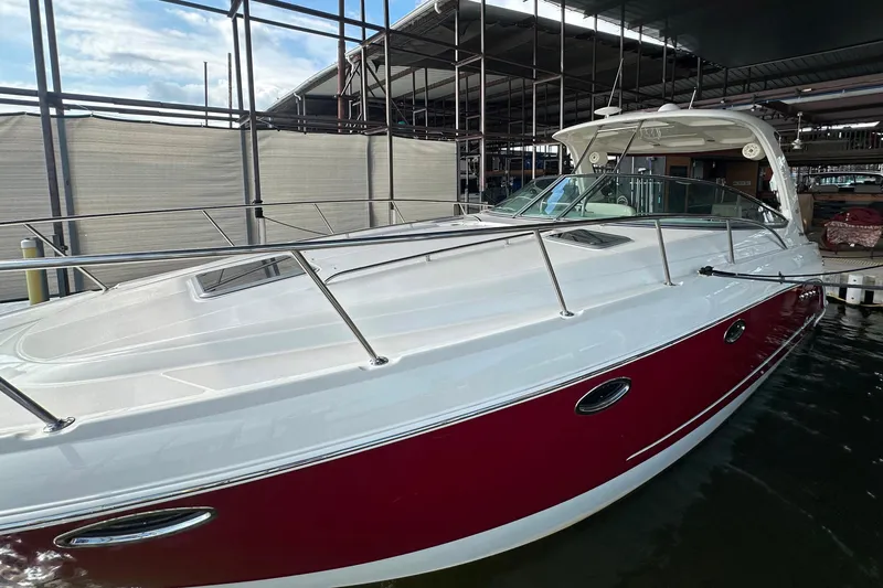Slide: The Image of 2010 Chaparral Signature 370 boat docked, featuring sleek red and white design. - 2