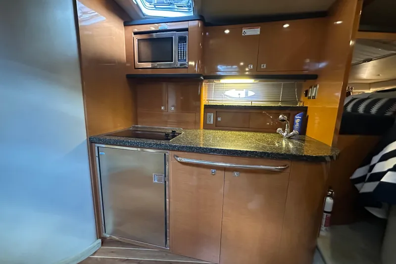 Slide: The Image of 2010 Chaparral Signature 370 yacht interior kitchen with microwave, sink, and mini-fridge. - 35