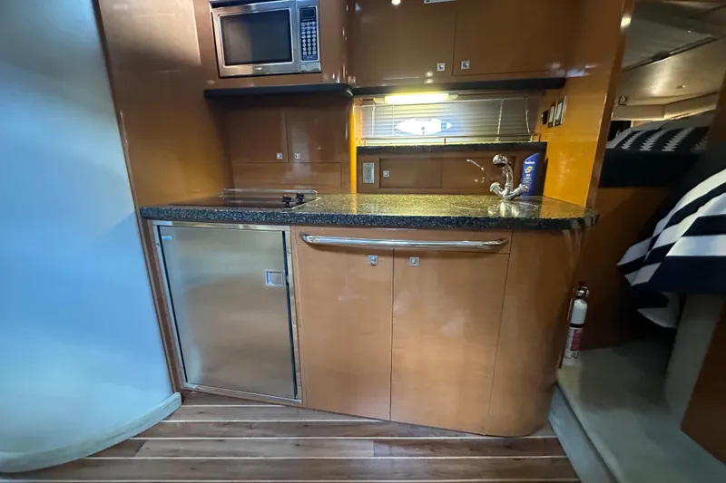 Slide: The Image of Chaparral Signature 370 yacht interior kitchen with microwave, sink, and wooden cabinetry, 2010 model. - 36