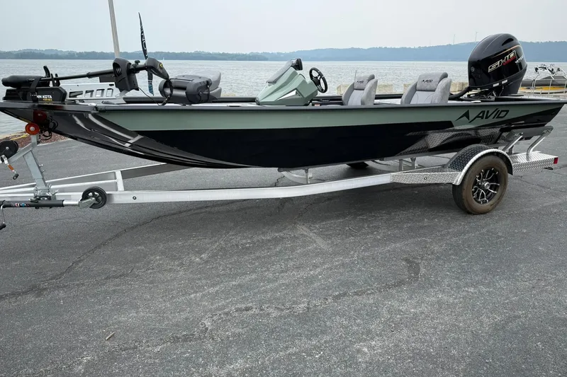 The Image of Avid 18 Vertex 2025 fishing boat on trailer by a lake. - 1