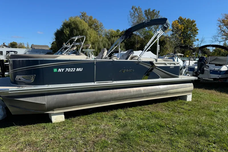 The Image of 2022 Avalon LSZ Quad Lounger 2385 pontoon boat on grass, sunny day. - 1