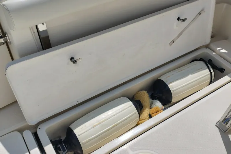 Slide: The Image of Storage compartment on a 1995 Tiara Yachts 2900 Open, containing boat fenders and cleaning supplies. - 17