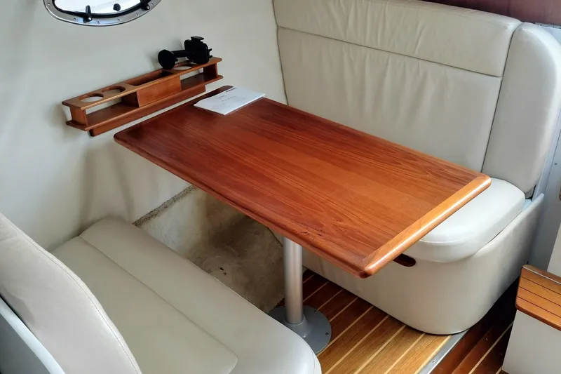 Slide: The Image of 1995 Tiara Yachts 2900 Open interior with wooden table and cushioned seating. - 6