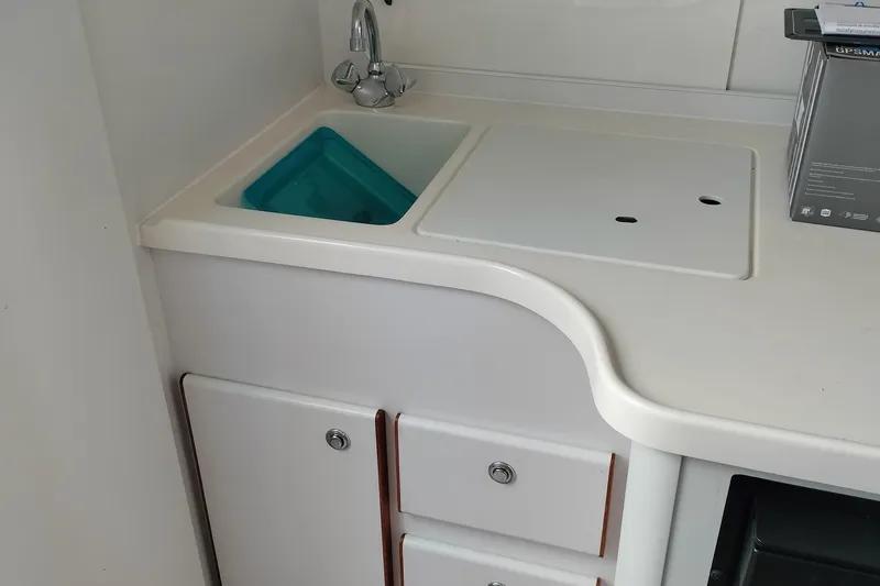 Slide: The Image of 1995 Tiara Yachts 2900 Open galley with sink, faucet, and storage cabinets. - 9