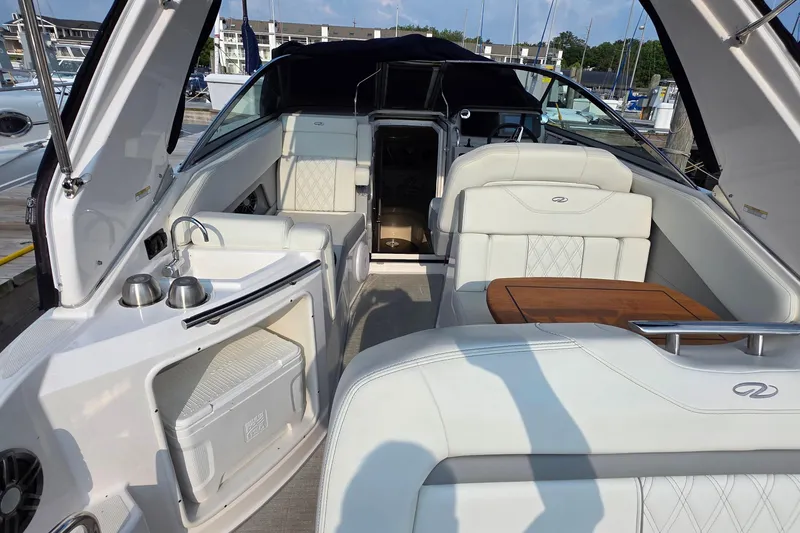 Slide: The Image of 2022 Regal 28 Express boat interior with white seating and wooden table. - 13