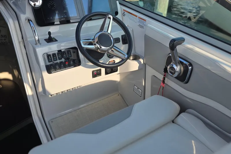 Slide: The Image of 2022 Regal 28 Express boat helm with steering wheel and control panel. - 15