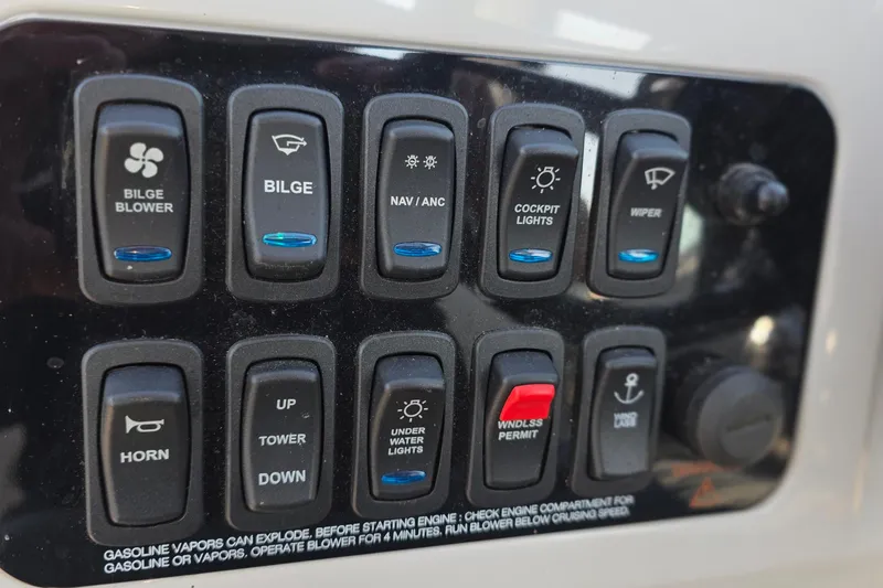 Slide: The Image of Control panel of a 2022 Regal 28 Express boat with various switches. - 21