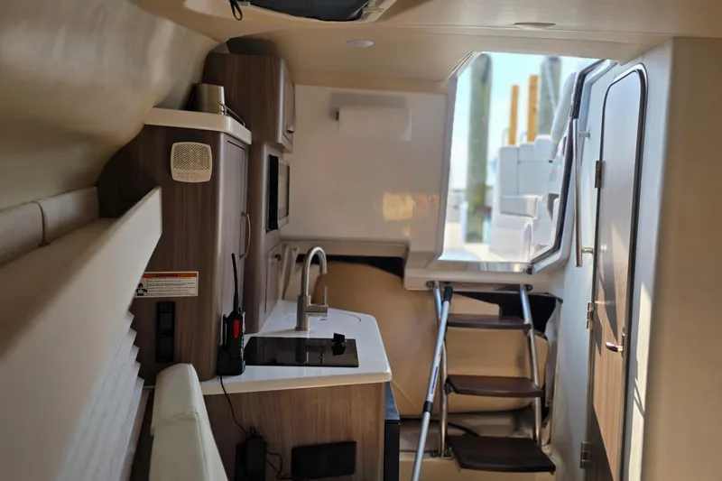 Slide: The Image of 2022 Regal 28 Express boat interior with kitchenette and stairs leading outside. - 23
