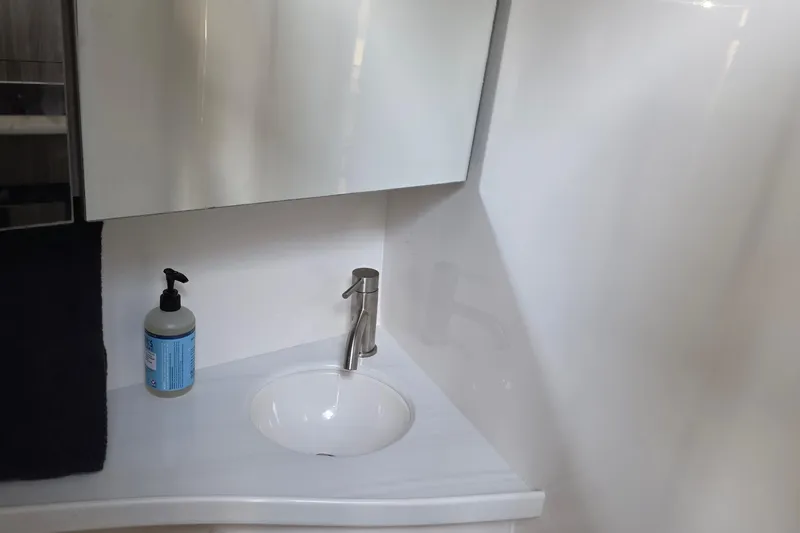 Slide: The Image of Modern bathroom sink in 2022 Regal 28 Express boat, featuring sleek faucet and soap dispenser. - 31