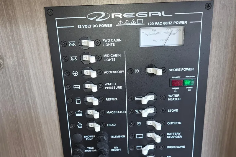 Slide: The Image of Control panel of a 2022 Regal 28 Express boat, featuring power switches and indicators. - 33