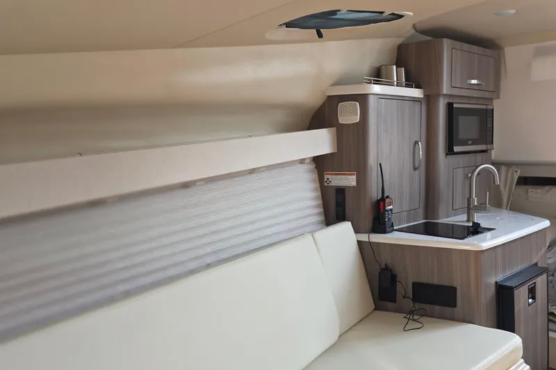 Slide: The Image of Interior of 2022 Regal 28 Express boat with modern kitchenette and seating area. - 35
