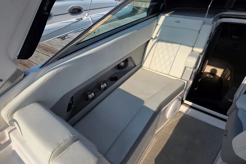 Slide: The Image of 2022 Regal 28 Express boat interior with cushioned seating and cup holders. - 37