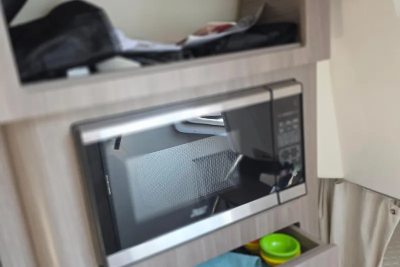 Slide: The Image of Microwave in 2022 Regal 28 Express boat interior, with storage shelves. - 38