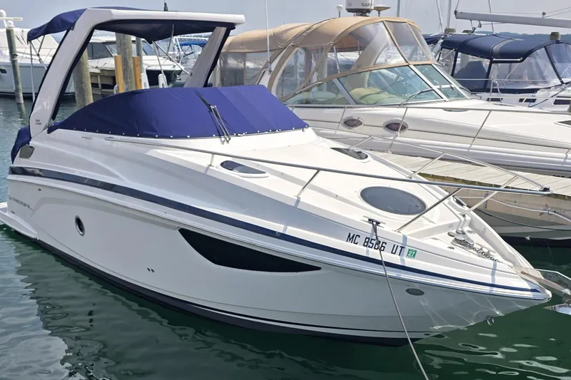 Slide: The Image of 2022 Regal 28 Express boat docked in marina with blue cover. - 4