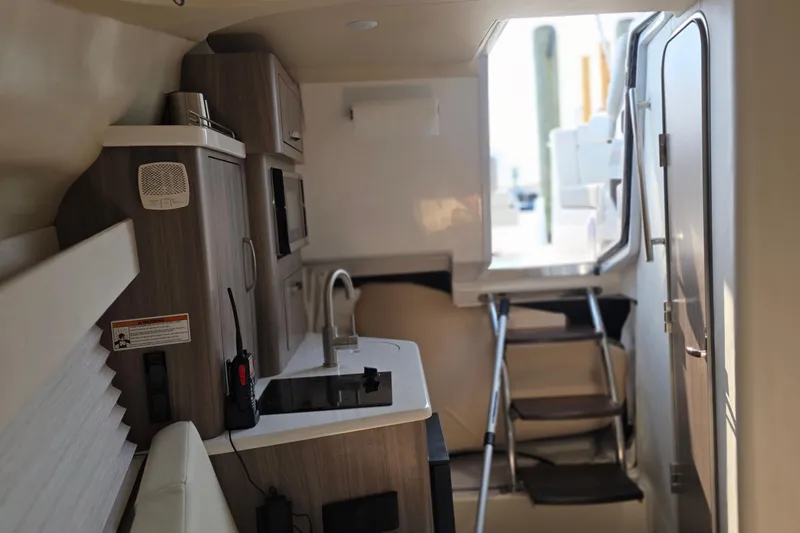 Slide: The Image of Interior of 2022 Regal 28 Express boat featuring modern kitchenette and compact design. - 41