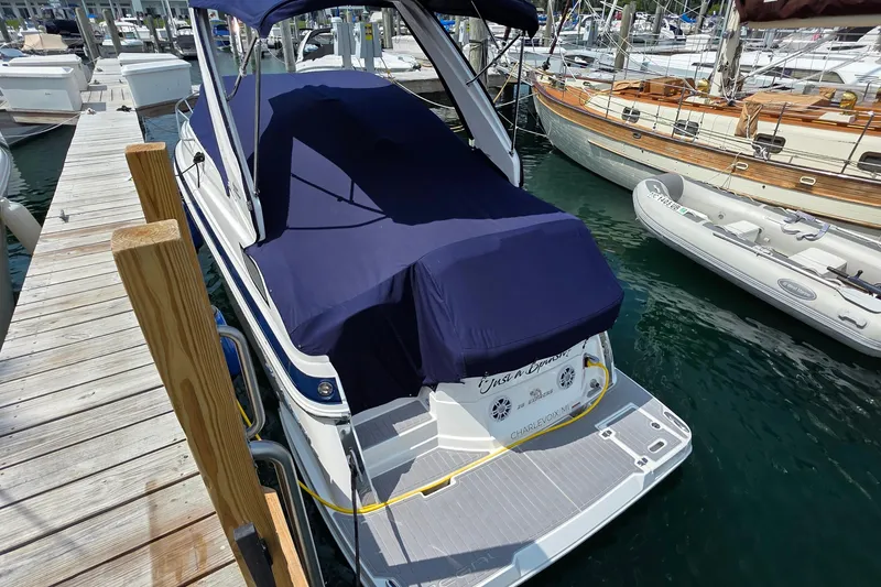 Slide: The Image of 2022 Regal 28 Express boat docked in marina, featuring sleek design and blue canopy. - 7
