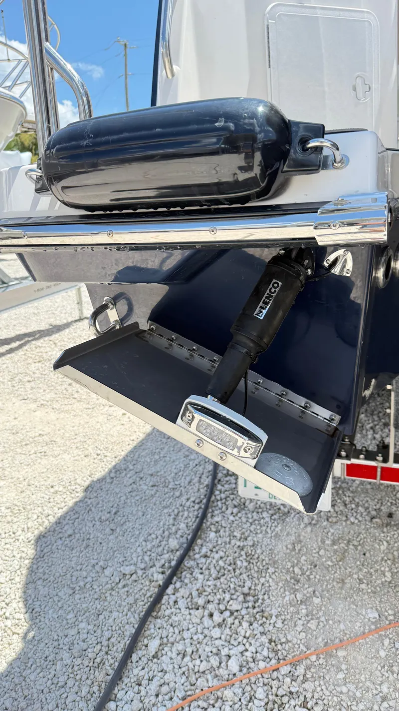 Slide: The Image of 2026 Cutwater C-288 Coupe boat detail with trim tab and fender on gravel. - 11
