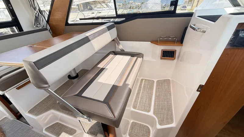 Slide: The Image of 2026 Cutwater C-288 Coupe interior seating with table and window view. - 25