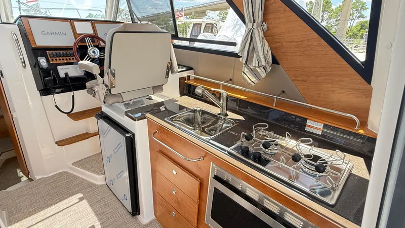 Slide: The Image of Interior of 2026 Cutwater C-288 Coupe featuring helm, kitchen, and modern appliances. - 29