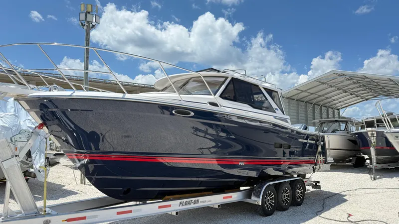 Slide: The Image of 2026 Cutwater C-288 Coupe boat on trailer under clear blue sky. - 3
