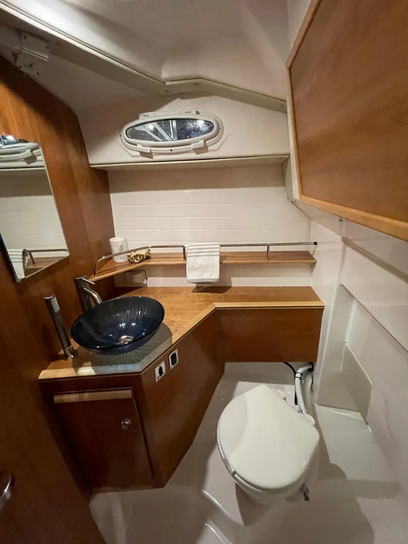 Slide: The Image of 2026 Cutwater C-288 Coupe bathroom with modern sink, wooden cabinetry, and porthole window. - 35