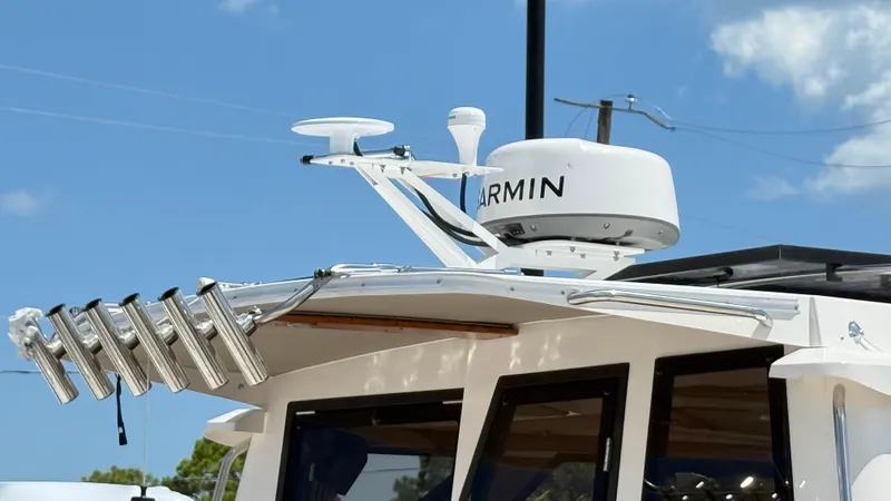 Slide: The Image of 2026 Cutwater C-288 Coupe with Garmin radar and rod holders under clear sky. - 6