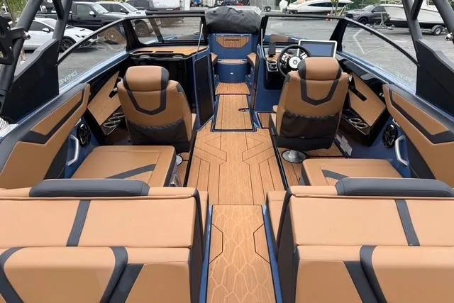 Slide: The Image of 2024 Yamaha Boats 222XD interior with tan and black seating, modern dashboard, and spacious layout. - 7