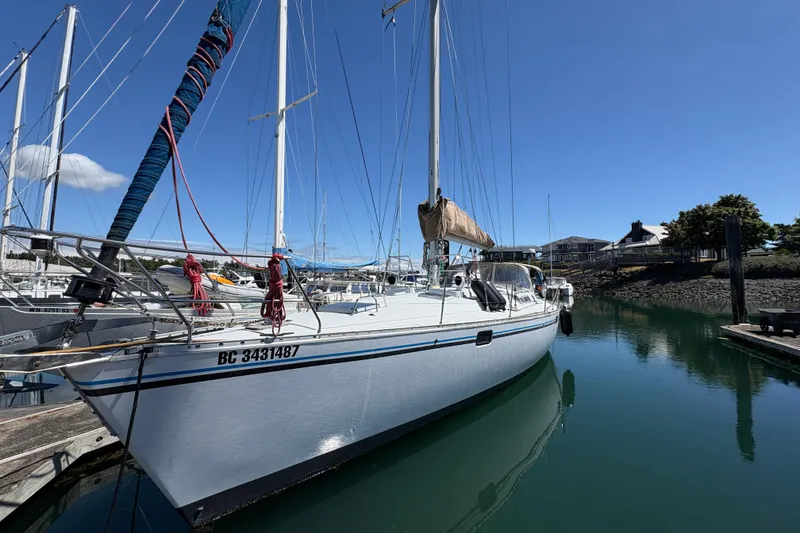 Slide: The Image of 1990 Beneteau Oceanis 500 sailboat docked in a marina under clear blue skies. - 2
