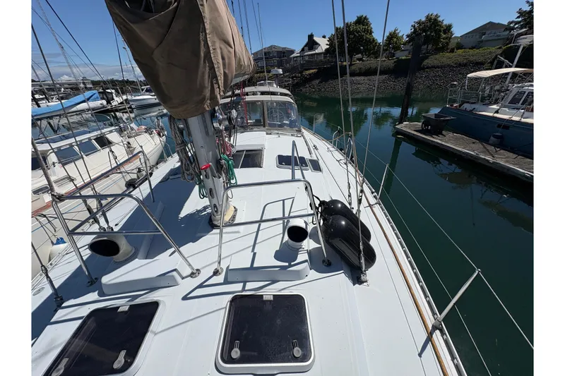 Slide: The Image of Deck view of a 1990 Beneteau Oceanis 500 sailboat docked in a marina. - 26