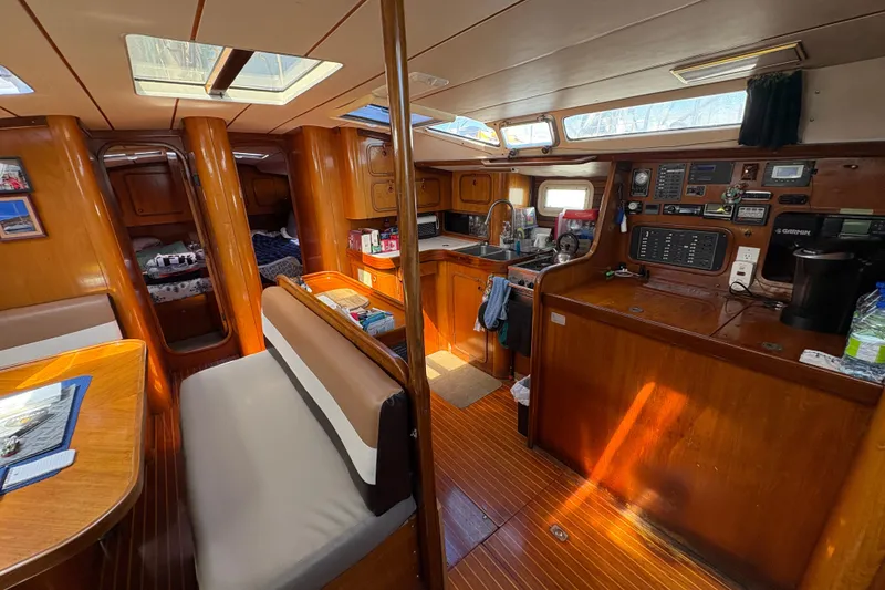 Slide: The Image of Interior of a 1990 Beneteau Oceanis 500 sailboat with wood finish and cozy seating. - 56