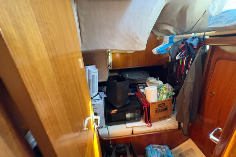 Slide: The Image of Interior of 1990 Beneteau Oceanis 500 sailboat with storage and hanging clothes. - 90