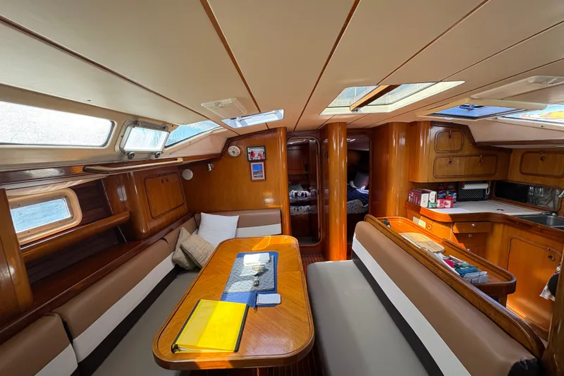 Slide: The Image of Interior of 1990 Beneteau Oceanis 500 sailboat with wood finish and cozy seating area. - 92