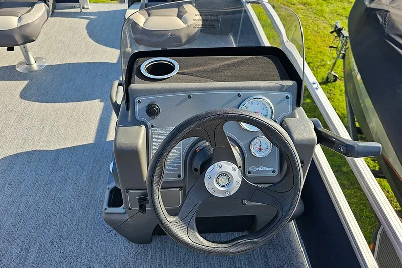 Slide: The Image of 2026 Sun Tracker Bass Buggy 18 DLX steering console with gauges and cup holder. - 17