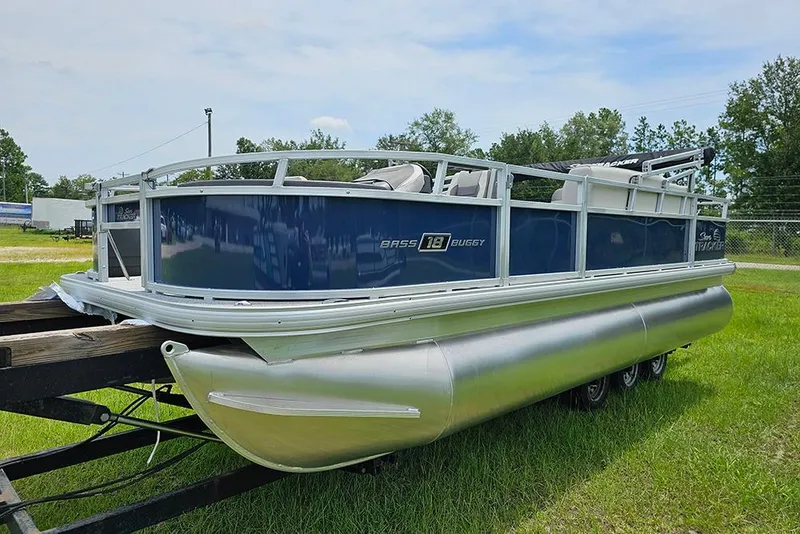 Slide: The Image of 2026 Sun Tracker Bass Buggy 18 DLX pontoon boat on trailer, parked on grass. - 5