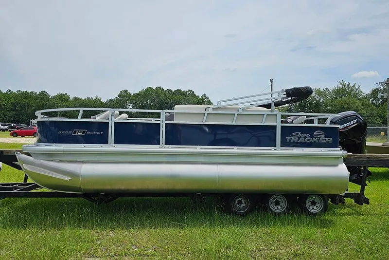 Slide: The Image of 2026 Sun Tracker Bass Buggy 18 DLX pontoon boat on trailer, parked on grass. - 6