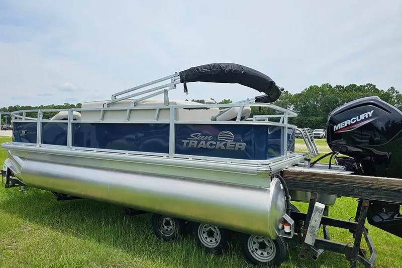 Slide: The Image of 2026 Sun Tracker Bass Buggy 18 DLX pontoon boat with Mercury outboard motor on trailer. - 7