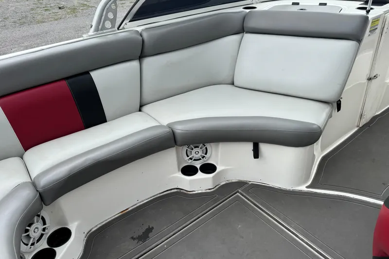 Slide: The Image of 2004 Tigé 22V Riders Edition boat interior with gray and red seating. - 6